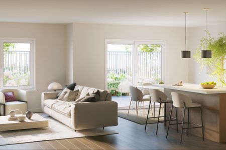 Bright modern living room and kitchen with large windows, island seating, and neutral-colored furniture.